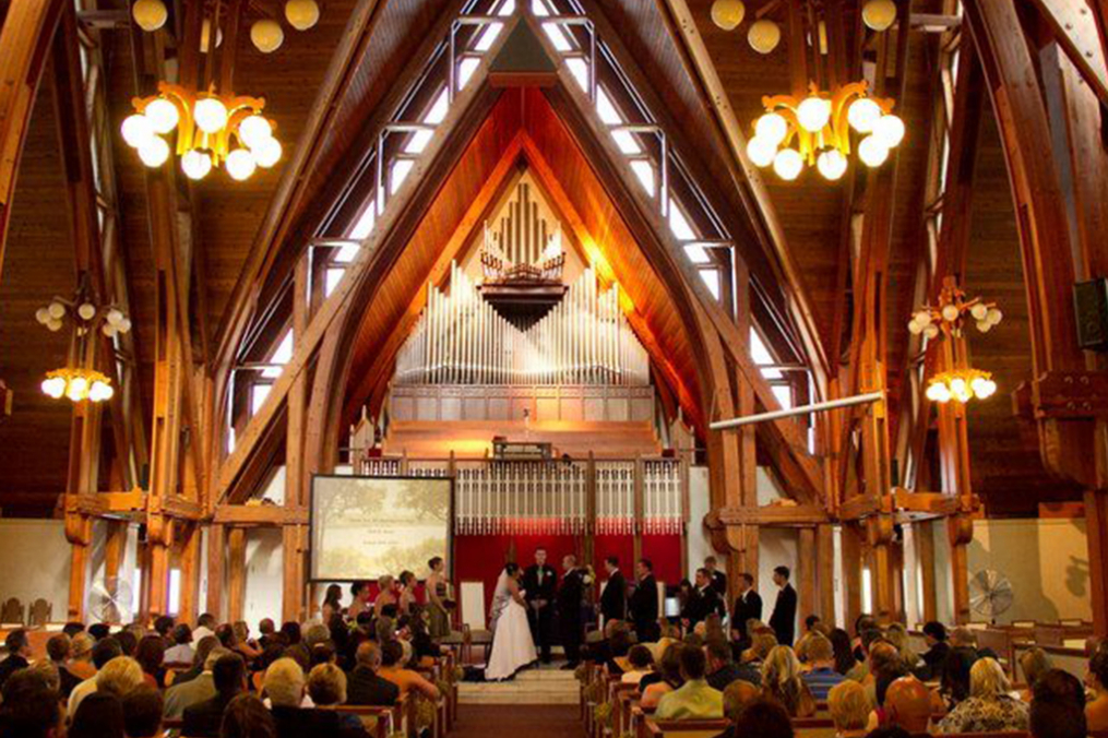 Norton Chapel interior with a bride and groom at the altar and their guests seated around them