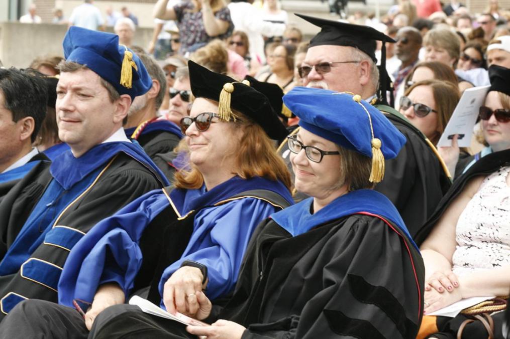 Dr. Jennie Joiner, right, chair of the Division of Humanities and Fine Arts and associate professor of English, gets a reassuring squeeze of the hand from colleague Anne Weed as it becomes apparent she is being named Professor of the Year.