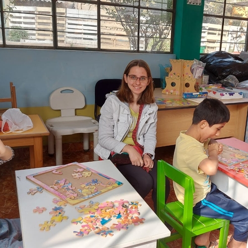 Keuka College student Franccesca sits next to student in a classroom in Peru
